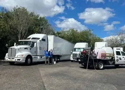 Two men standing next to a white truck.